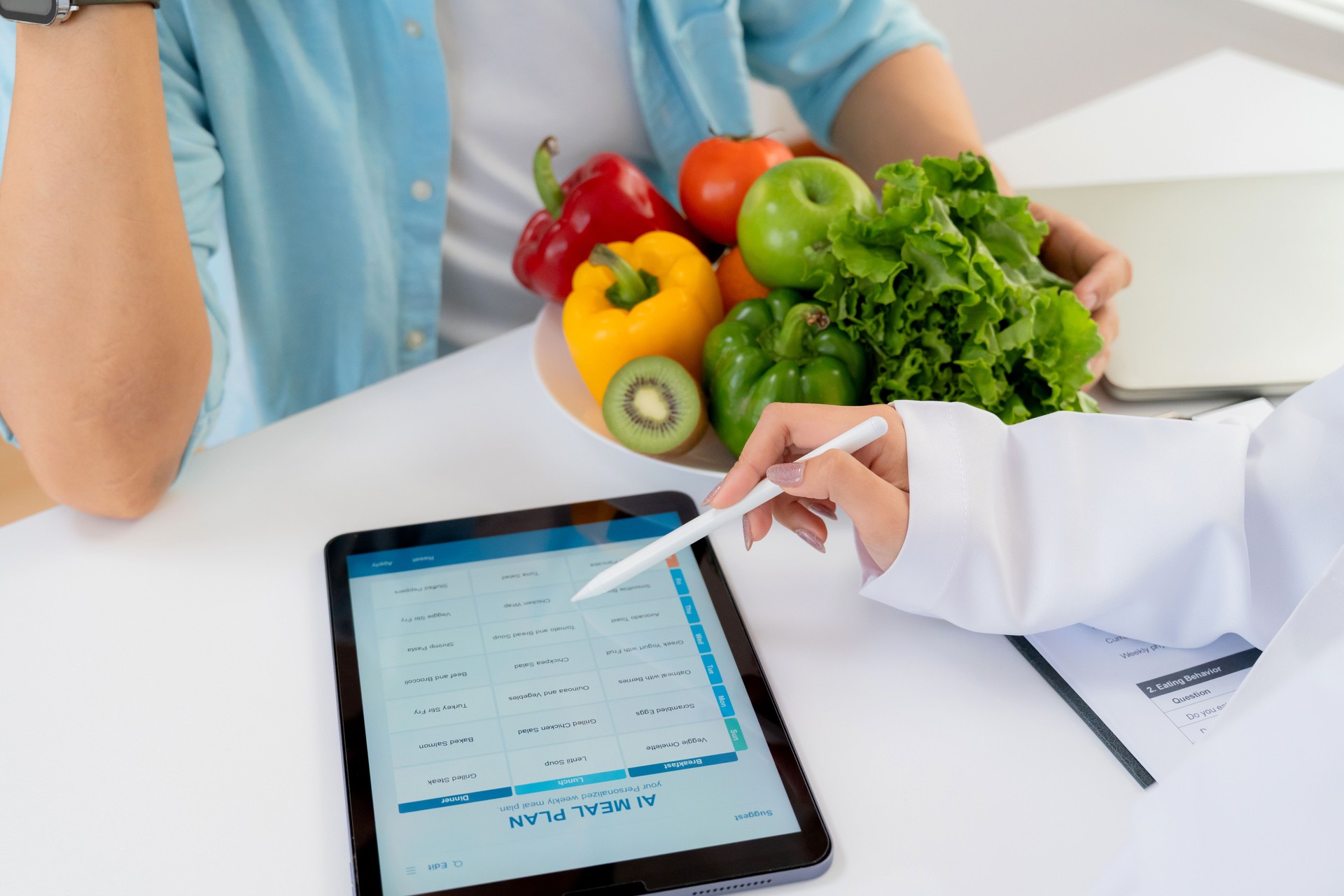 Asian nutritionist using tablet to explaining personalized meal plan with AI to patient during healthcare consultation, healthy lifestyle, woman dietitian showing nutrition plan with AI on tablet.